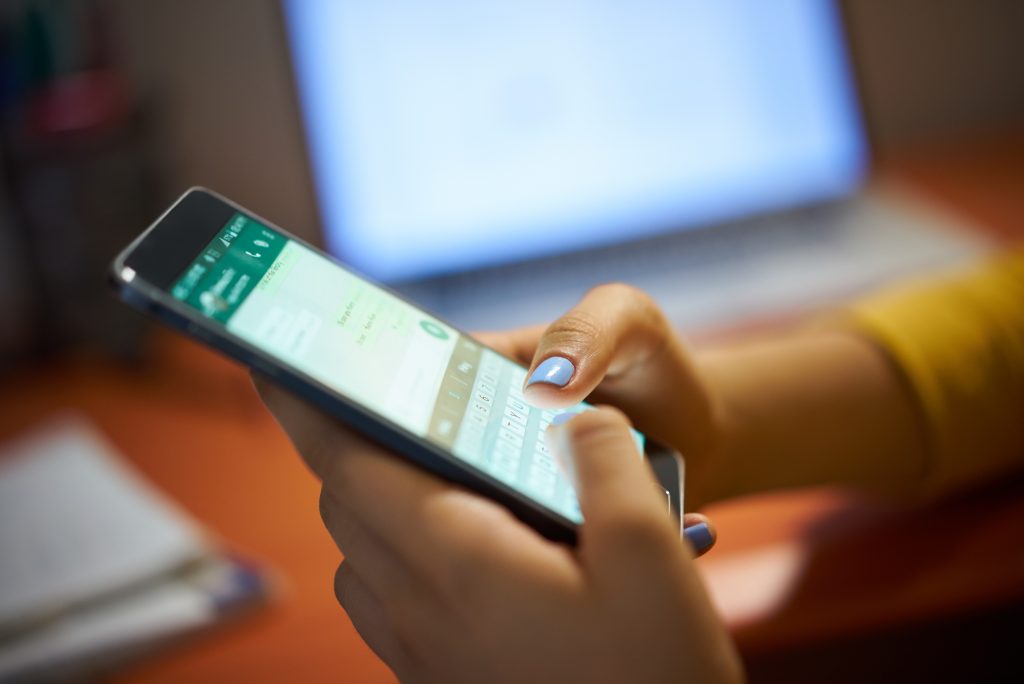 Girl Typing Phone Message On Social Network At Night